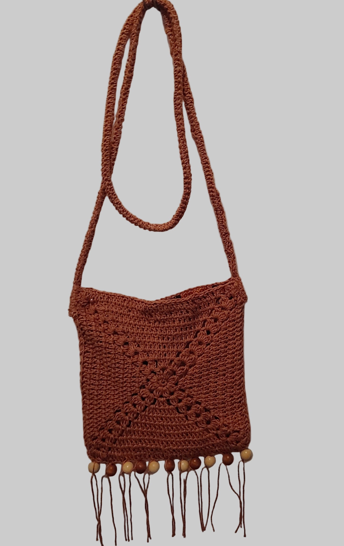 Brown rochet hands free bag with fringe and wooden beading.