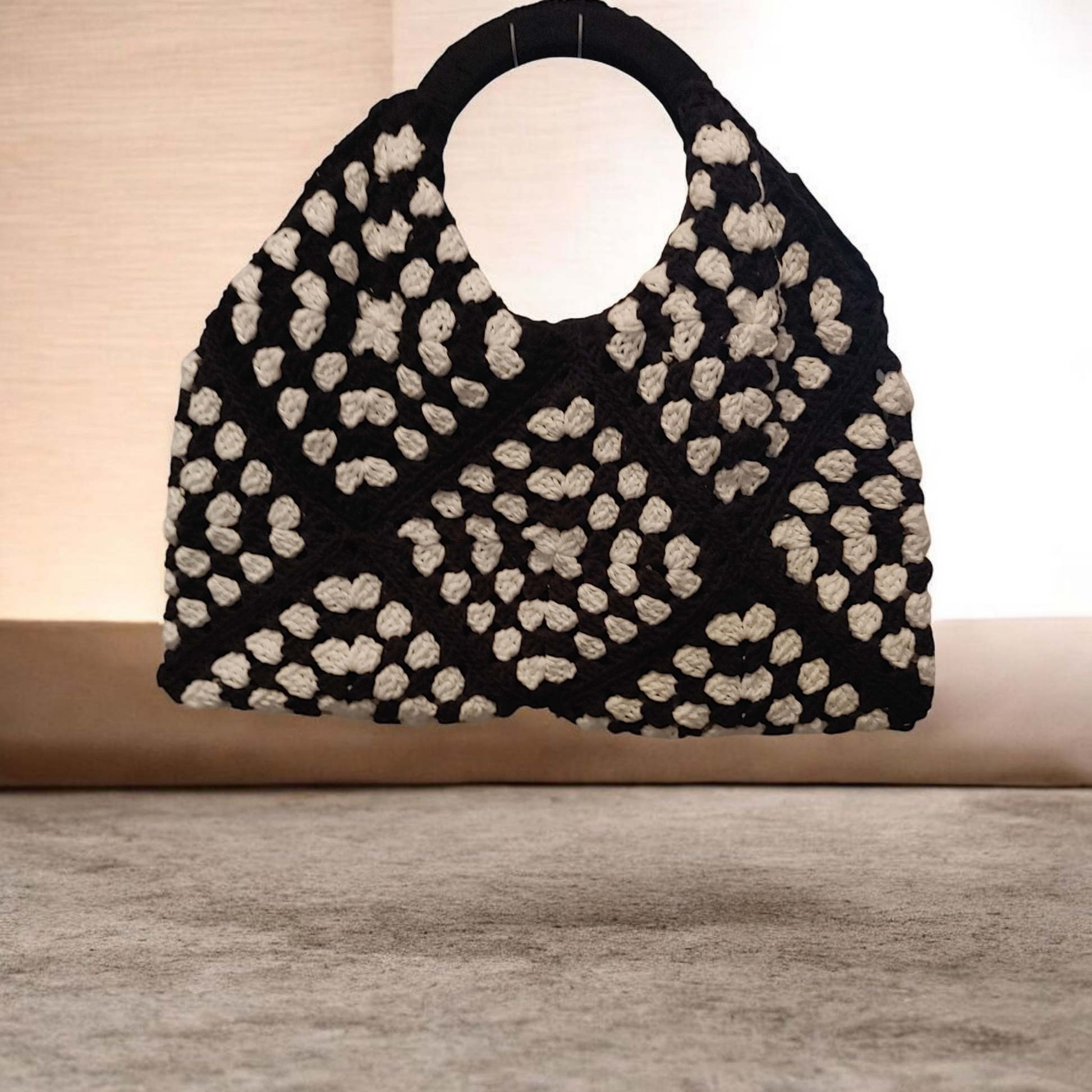 Black and white Artisan crochet handbag with covered wooden handle.