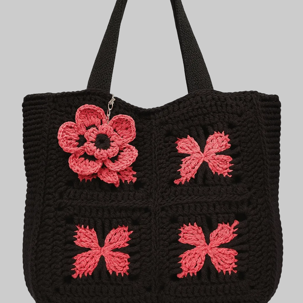 Handmade black crochet tote bag with coral floral motifs, sustainable and eco-friendly design